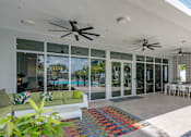 Thumbnail 24 of 35 - A patio with a white couch and a colorful rug.