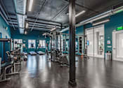 Thumbnail 6 of 35 - A gym with a variety of equipment and a green exit sign.