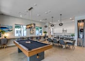 Thumbnail 12 of 35 - A pool table is in the middle of a room with a bar and a dining table.