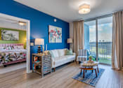 Thumbnail 19 of 35 - A living room with a blue wall and a white couch.