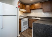 Thumbnail 8 of 16 - a kitchen with a white refrigerator freezer next to a white stove top oven