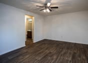 Thumbnail 11 of 16 - a living room with white walls and a ceiling fan
