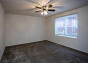 Thumbnail 13 of 16 - an empty room with a ceiling fan and a window