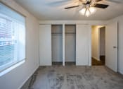 Thumbnail 12 of 16 - a bedroom with white walls and a ceiling fan