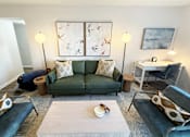 Thumbnail 10 of 38 - A living room with a green couch and a white coffee table.