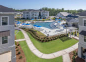 Thumbnail 19 of 54 - an aerial view of a resort style pool with lounge chairs and umbrellas