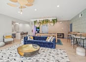 Thumbnail 6 of 36 - A living room with a blue sofa and a gold bowl on the floor.