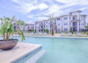 Thumbnail 49 of 60 - a large swimming pool with apartment buildings in the background