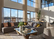 Thumbnail 3 of 40 - a living room with large windows and a couch and a table