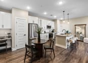 Thumbnail 71 of 94 - a kitchen and dining room with white cabinets and a table
