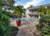 Thumbnail 19 of 34 - a swimming pool with palm trees in front of a house at L'Estancia, Sarasota, FL