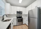 Thumbnail 4 of 59 - a kitchen with white cabinets and a stainless steel wall