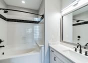 Thumbnail 17 of 59 - a bathroom with a tub and a sink and a mirror