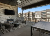 Thumbnail 42 of 94 - a patio with a table and chairs and a fireplace