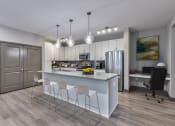 Thumbnail 9 of 25 - a kitchen with white cabinets and a large island with chairs