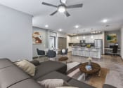 Thumbnail 13 of 25 - a living room and kitchen with a couch and a ceiling fan