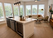 Thumbnail 37 of 40 - A kitchen with a large island and a dining table with chairs.