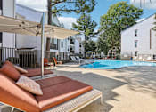 Thumbnail 24 of 28 - A pool area with a sun lounger and a white umbrella.