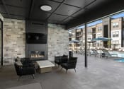 Thumbnail 46 of 94 - a patio with chairs and a fireplace and a pool with umbrellas