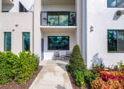 Thumbnail 3 of 78 - the walkway to the entrance of a building with a patio at Altis Blue Lake, Lake Worth, FL, 33467