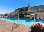Thumbnail 63 of 94 - a swimming pool with chairs and a building in the background