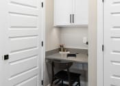 Thumbnail 74 of 94 - a small desk with two chairs in a room with white cabinets