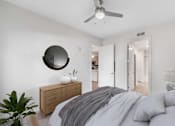Thumbnail 12 of 57 - Decatur, GA Apartments Near Emory Hospital - ARLO - Spacious Bedroom With Vinyl Plank Flooring, Large Bed, Nightstand With Lamp, Dresser, Ceiling Fan, And Attached Bathroom.