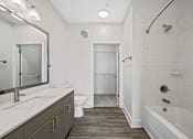 Thumbnail 19 of 57 - A white bathroom with a wooden floor and a white tub.