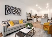 Thumbnail 7 of 46 - 1-Bedroom Apartments in Norcross, GA - The Darnell - Open Layout Living Room with Wood-Style Floor, Area Rug, Couch, Armchair, Coffee Table, Wall Art, and View of Kitchen