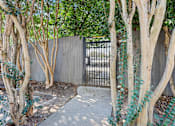 Thumbnail 23 of 28 - A tree-lined walkway leads to a gate.