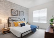 Thumbnail 10 of 46 - 3 BR Apartments in Norcross GA - The Darnell - Furnished Bedroom with Carpeted Floors, Bed, Window, Nightstands, Lamps, and Dresser