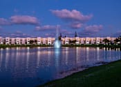Thumbnail 59 of 78 - A fountain in the middle of a lake surrounded by buildings.