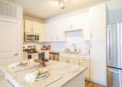 Thumbnail 3 of 60 - a kitchen with white cabinets and a counter top