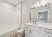 Thumbnail 20 of 36 - A white bathroom with a toilet, sink, and mirror.
