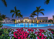 Thumbnail 58 of 78 - A pool surrounded by red flowers at dusk.