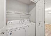 Thumbnail 33 of 36 - A white laundry room with a washer and dryer.