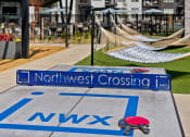 Thumbnail 54 of 94 - a playground with a northwest crossing sign and hammocks on the ground