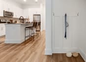 Thumbnail 6 of 46 - a kitchen with white cabinets and a large island with a breakfast bar and stools
