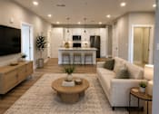 Thumbnail 2 of 11 - A modern living room with a kitchen in the background.