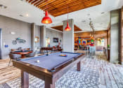 Thumbnail 25 of 34 - 2-Bedroom Apartments in Maitland, FL - The Parker at Maitland Station - Clubhouse with a Mini Kitchen, Table with Chairs, Billiards Table, and Foosball Table.