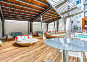 Thumbnail 21 of 34 - Apartments in Maitland, FL for Rent - The Parker at Maitland Station - Shaded Poolside Lounge Area with Comfortable Seating.