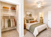 Thumbnail 12 of 35 - A bedroom with a bed, dresser, and closet.