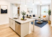 Thumbnail 8 of 35 - A modern kitchen with a large island and a dining area.
