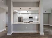 Thumbnail 17 of 37 - A kitchen with a sink and a refrigerator.