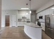 Thumbnail 24 of 37 - A modern kitchen with stainless steel appliances and a central island.