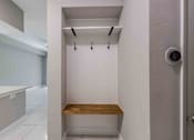 Thumbnail 27 of 37 - A small white bathroom with a wooden bench.