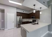 Thumbnail 15 of 37 - A kitchen with a white countertop and a stainless steel refrigerator.