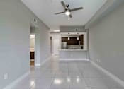 Thumbnail 18 of 37 - A spacious room with a ceiling fan and tiled flooring.