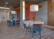 Thumbnail 7 of 40 - a dining area with a round table and chairs and a large pillar with a wall