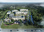 Thumbnail 4 of 28 - an aerial view of a building surrounded by trees and a highway